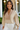 Woman wearing a beige blouse with intricate lace detailing in a casual setting.