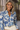 Woman wearing a blue floral blouse with a blurred background
