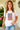Woman wearing a white t-shirt with an American flag design on a plain background